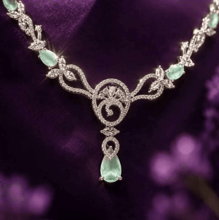 A Uji diamond and emerald necklace on purple silk